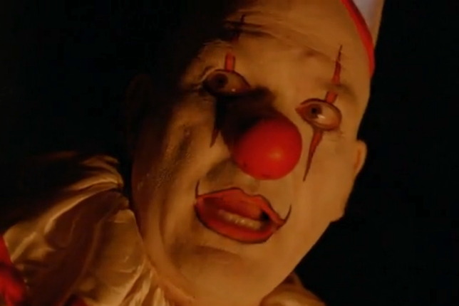 Twisted Clown, played by actor John Carroll Lynch in the FX show American Horror Story.  Red clown nose, white makeup, red lips with two long streaks up and down across the eyes.